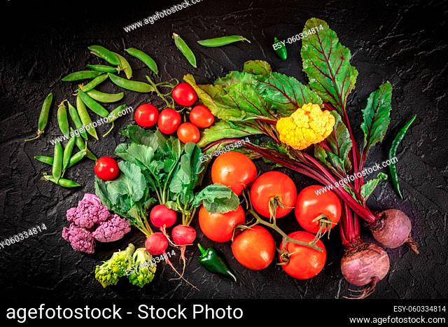 Fresh vegetable background with many groceries, shot from the top on a black background. Healthy vegan salad ingredients