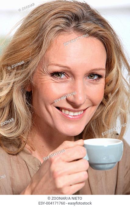 mature blonde woman with a cup of coffee