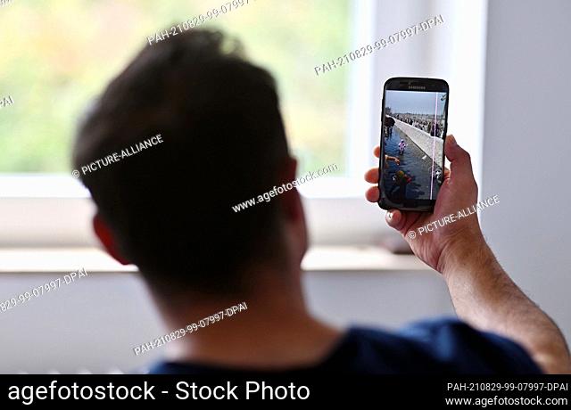 27 August 2021, Baden-Wuerttemberg, Karlsruhe: A fugitive who worked as an Afghan local force shows a photo on a mobile phone which he says he took when he fled...