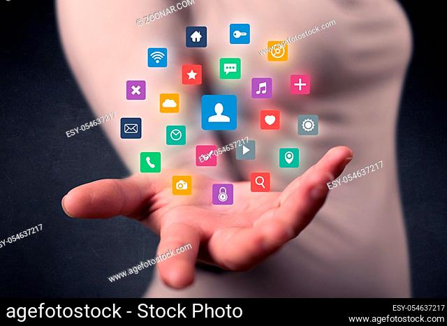 Colorful multimedia icons in the hands of a young casual businesswoman