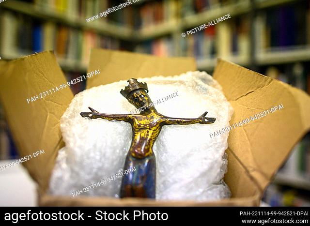 14 November 2023, Saxony-Anhalt, Magdeburg: A bronze crucifix from the 13th century lies on bubble wrap in a cardboard box