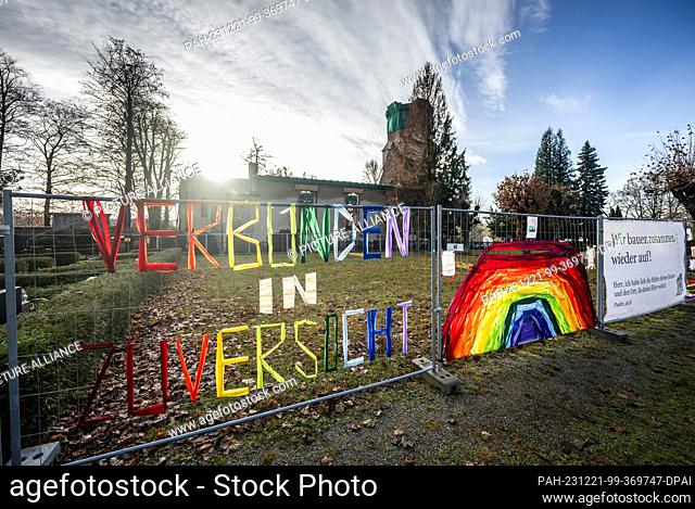 PRODUCTION - 20 December 2023, Saxony, Großröhrsdorf: A construction fence with the inscription ""United in Confidence"" stands in front of the ruins of the...