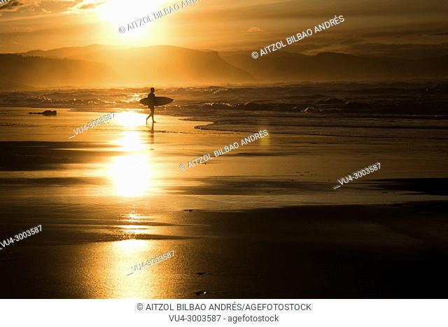 Sunset surfer in Atxabiribil beach, Sopelana, Basque country. The Basque country is a perfect place for surfing with a lot of sand breaks