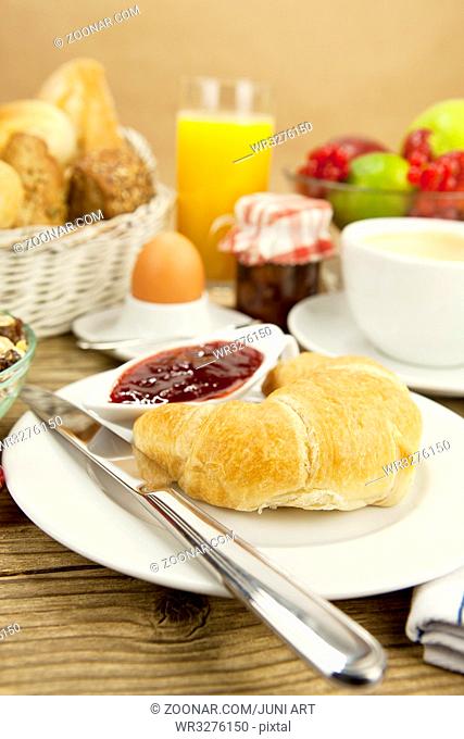 französisches Frühstück mit croissant, Saft und marmelade auf einem Holztisch