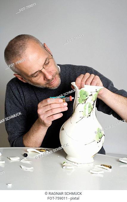 A man repairing a broken vase