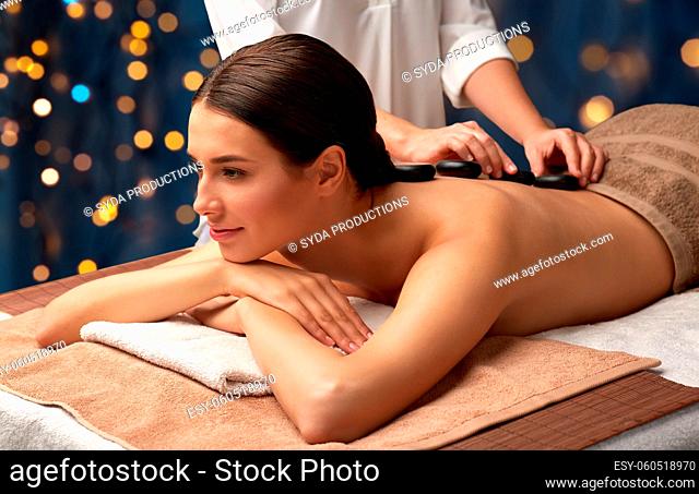 beautiful woman having hot stone massage at spa