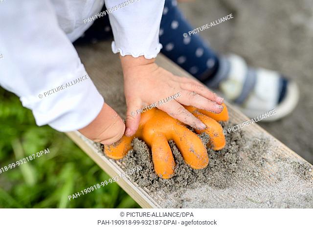 17 September 2019, Bavaria, Valley: A 22-month-old girl who was born with only one hand plays with a sandbox shape. In the past few months