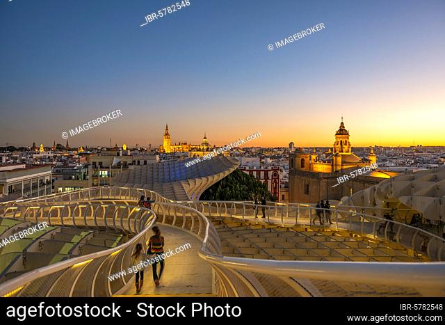 View over Sevilla from Metropol Parasol at sunset, curved wooden construction, Cathedral of Sevilla with tower La Giralda
