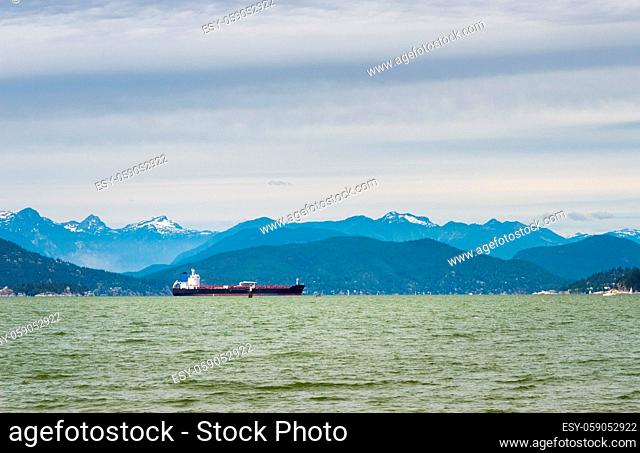 Commercial tanker ship in waters of Howe Sound with Coastal Mountains in background. Taken from Tower Beach, Vancouver, British Columbia, Canada
