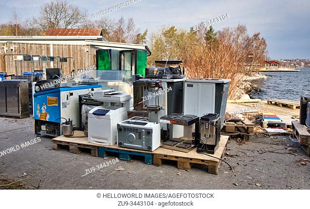 Old fridges and electrical equipment on waterfront waiting to be collected, Fjaderholmarna island, Stockholm archipelago, Sweden