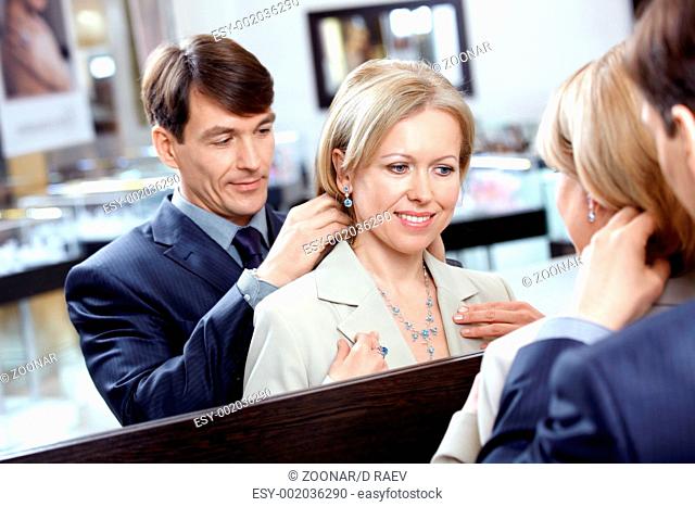 The man clasps a jeweller necklace to the woman