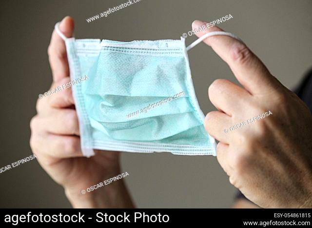 Woman putting on a protection mask to prevent from COVID-19 and other infections