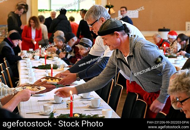 06 December 2023, Thuringia, Erfurt: Helpers serve a hot meal at the Evangelical City Mission's Restaurant des Herzens. From St