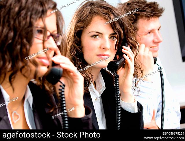 Young customer service operator team working at office, holding phone, calling, giving helpdesk support