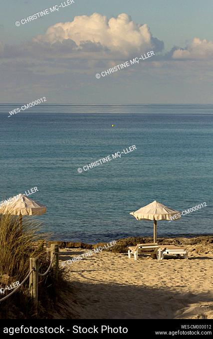Spain, Formentera, Es Arenals, sunshades and beach chairs