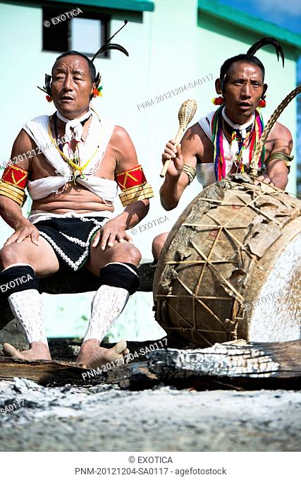 Naga tribal men in traditional outfit playing drum, Hornbill Festival, Kohima, Nagaland, India