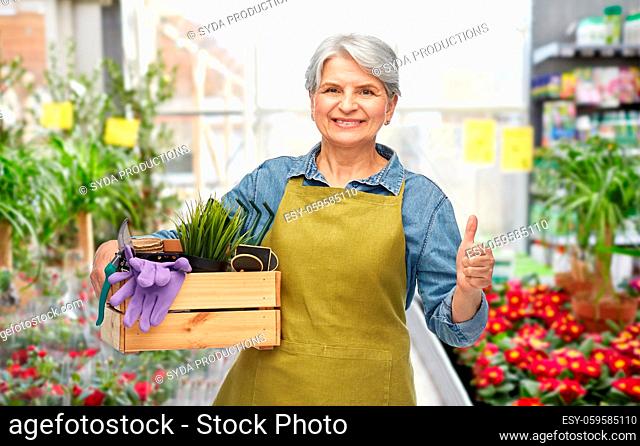 senior woman with garden tools showing thumbs up