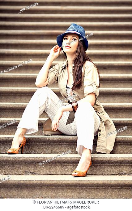 Woman wearing a hat sitting on a staircase