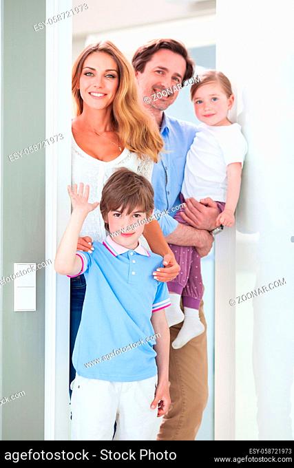 Portrait of happy smiling family with little children in doorway