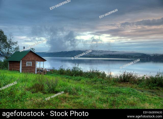 Vintage Russian smoke sauna log cabin on a river shore