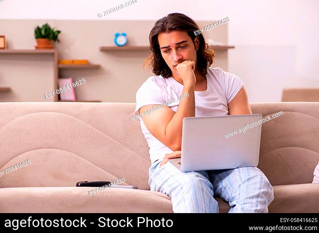 Young male student in oversleeping concept at home