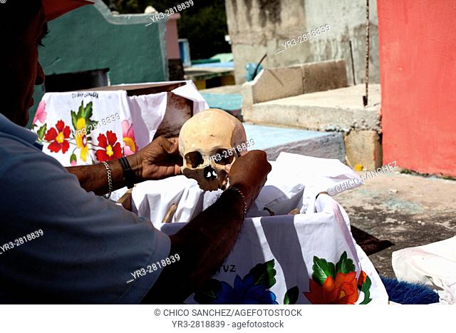 A man holds a skull in the Mayan village of Pomuch, Hecelchakan, Campeche, Yucatán península, October 30, 2016, as part of Day of the Dead celebrations in...
