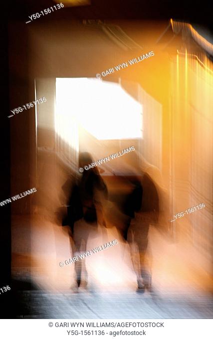 abstract two people walking in dark corridor at night