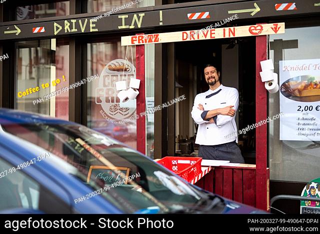 26 March 2020, Baden-Wuerttemberg, Weil am Rhein: Master baker Simon Fritz stands in the window of the improvised drive-in of his bakery