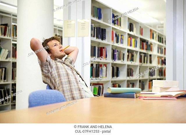 Young man working in library