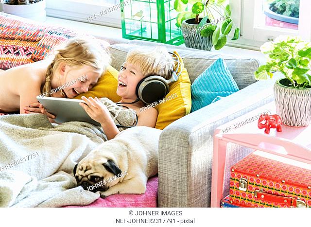 Kids using digital tablet on sofa