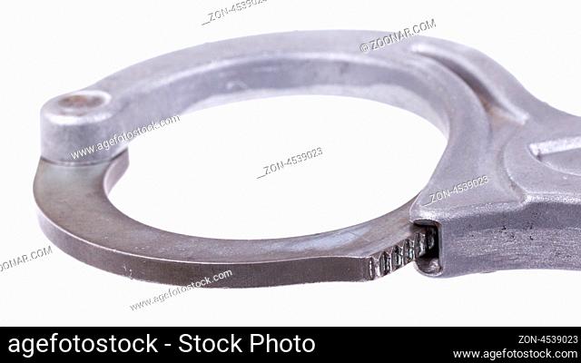 A close-up of metal handcuffs isolated on a white background