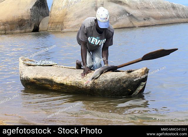 A fisherman is seen anchoring in bringing his catch from Lake Malawi to Senga Bay, to sell to beach revellers. Salima, Malawi