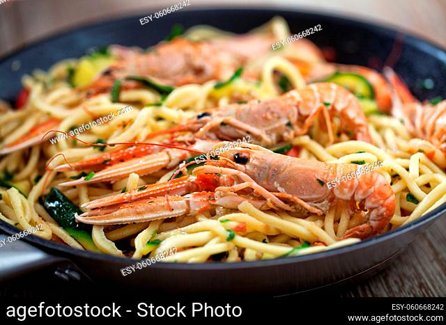 Handmade Tagliatelle with Prawns and Zucchini on a pan.. High quality photo