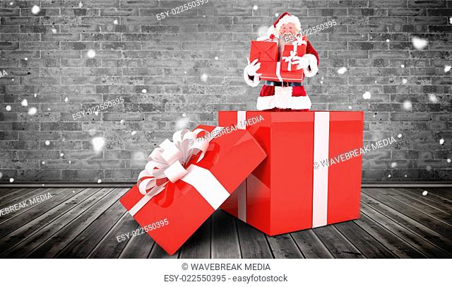 Composite image of santa standing in large gift