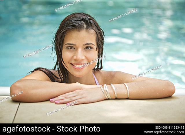 Woman relaxing at the edge of swimming pool