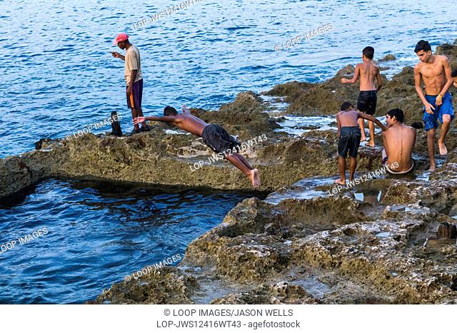 Young boys diving into the sea in Havana