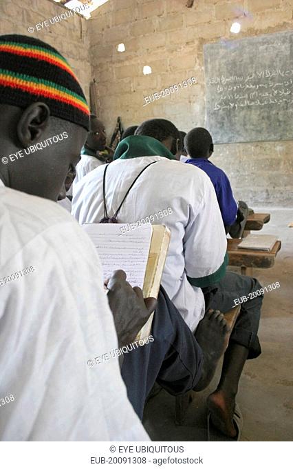 Tanji Village. Muslim boys writing in arabic at their desks while attending an islamic religious class at the Ousman Bun Afan Islamic school