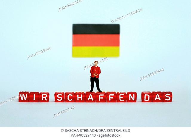 ILLUSTRATION - A small figurine of German Chancellor Angela Merkel stands under a German flag and on top of letter-dice spelling out ""WIR SCHAFFEN DAS"" (WE...