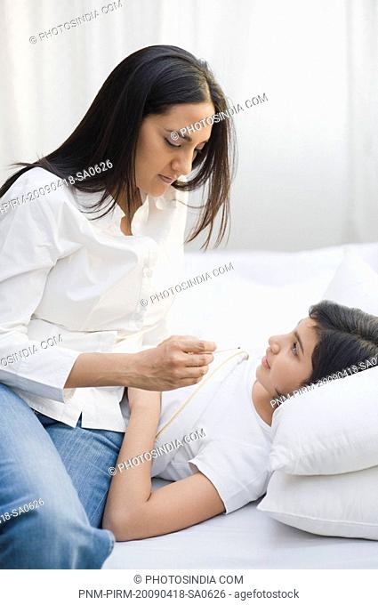 Woman checking her daughter's temperature