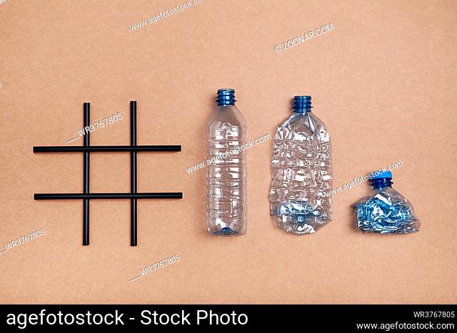 Hashtag recycling. Empty plastic bottles, cup and bottle cap put in a row after hashtag over blue background. Collecting plastic waste to recycling