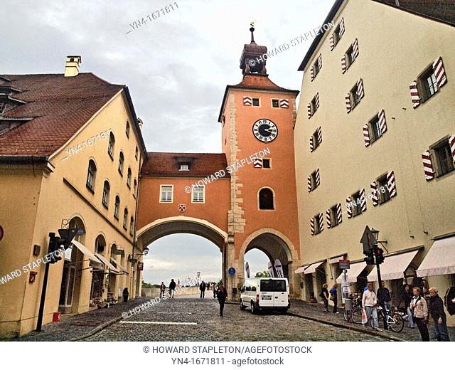 The old Salt House and Clock Tower mark the boarder of Old Town Regensburg at the point where the Old Stone Bridge through the archway crosses the Danube River...