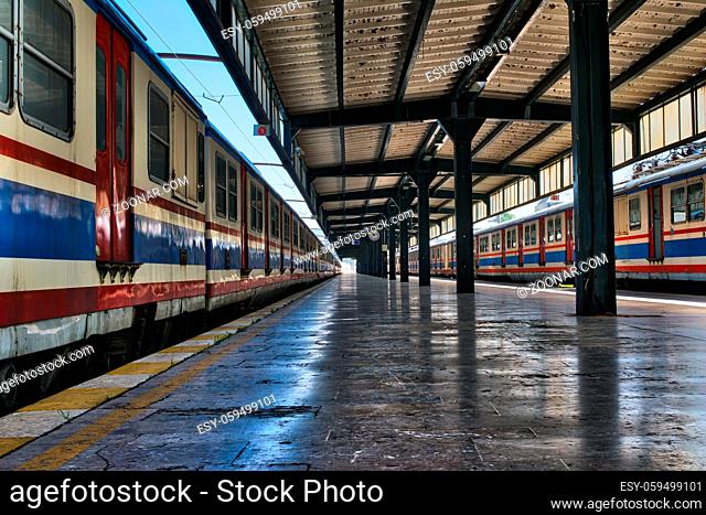 Interior shot of Haydarpasha Railway Terminal featuring metal truss and two colored stopped trains, Kadikoy, Istanbul, Turkey