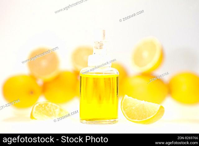 Lemon essential oil and lemon fruits on white background