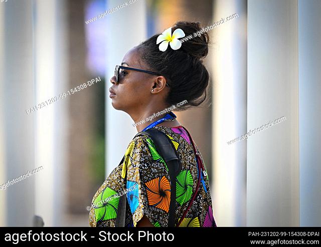 02 December 2023, United Arab Emirates, Dubai: A visitor with a flower in her hair arrives at the United Nations Climate Change Conference (COP28)