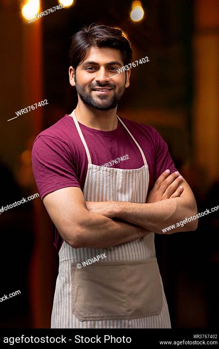 A CONFIDENT WAITER POSING IN FRONT OF CAMERA