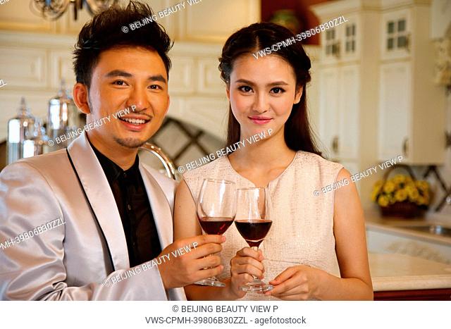 Young couple holding glasses of red wine