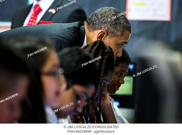 United States President Barack Obama looks at computer screens over the shoulders of seventh graders in a classroom that uses technology to enhance students'...