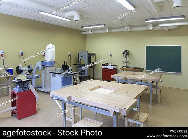 School classroom set up for a technical or practical course. Woodworking and light engineering. Clamps, machines and work surfaces