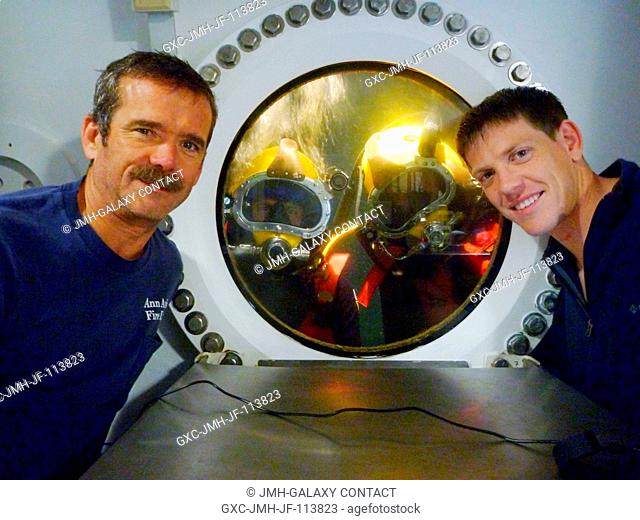 NEEMO 14 crew members Chris Hadfield (left), commander, and Andrew Abercromby (right) pose for a photo with Tom Marshburn and Steve Chappell who are...