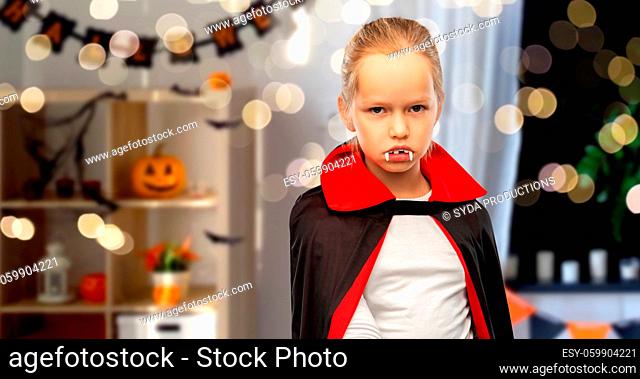girl in dracula costume with cape on halloween